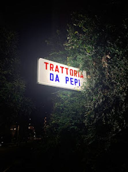 夜の木の中に光る TRATTORIA DA PEPI の看板
