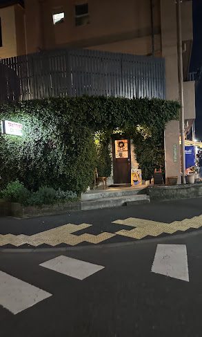 夜、蔦に覆われたトラットリア ダ ペピの入り口と看板