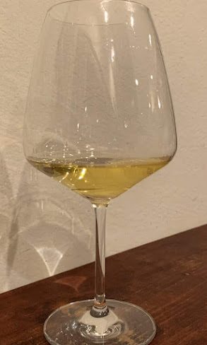 木のテーブルの上の白ワインのグラス